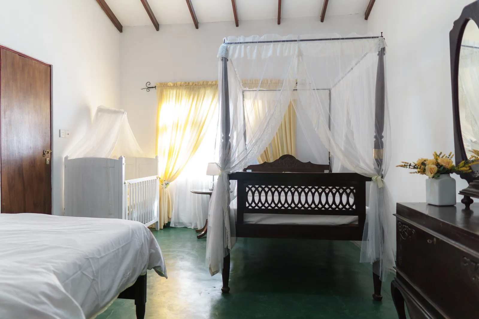 Daffodil bedroom: a double bed under a white canopy, with a single bed beside it